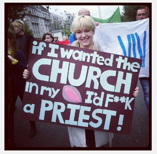 Pro-choice female protestor with a sign that says If I wanted the church in my uterus I'd F**K a priest!