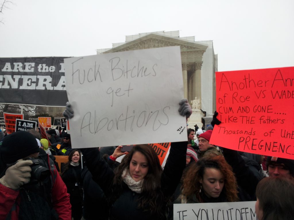 A female pro-choicers with a sign that says: F**K B***Hes get Abortions