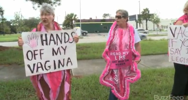 A photo of two grandmothers wearing vagina costumes with a sign that says: Hands off my vagina
