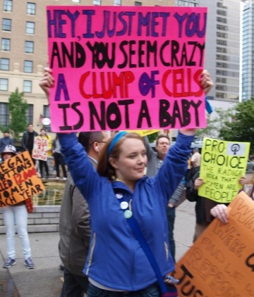 A female abortion supporter with a clever sign that rhymes: Hey, I just met you and you seem crazy a clump of cells is not a baby