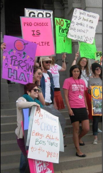 A group of abortion supporters with signs like" My Freedom of Choice brings all the boys & girls to the yard! Pro-Choice is Pro-Life, If health insurance pays for hard ons why shouldnt it offer birth control?