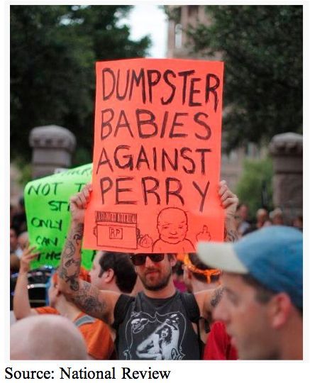 A photo from National Review of a male protester with a sign that says: Dumpster Babies again Perry. Then at the bottom is a drawing of a baby giving the finger
