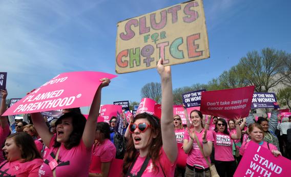 A photo of planned parenthood supporters and one female is holding a sign that reads: Sluts for Choice