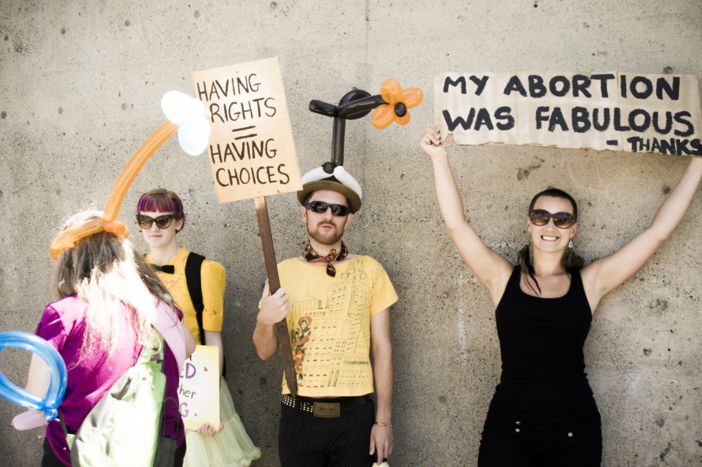A photo of a women holding a sign saying that: My Abortion Was Fabulous-Thanks