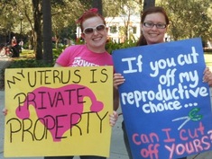A photo of two female protesters holding signs that say: "My Uterus is private property." "If you cut off my reproductive choice...Can I cut off yours?"