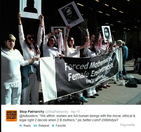 Photo from Stop Patriarchy's twitter of femal protestors holding a banner saying: Forced Motherhood is Femal Enslavement. The protesters are also holding bloody coat hangers