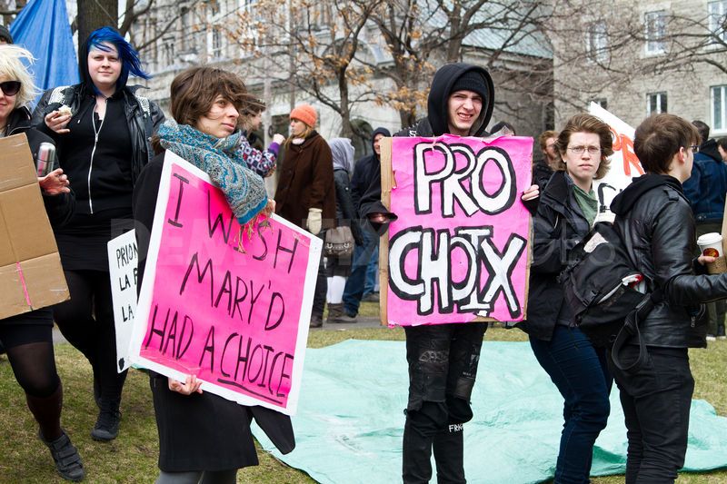 A photo taken at an abortion protest with a young female holding a sign that says: I wish Mary'd had a choice