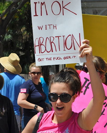 A photo of a female who's sign says: I'm Ok with abortion, get the f**k over it