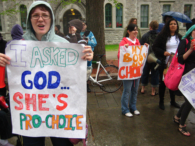 A female pro-choicer with a sign that says: I asked God she's pro-choice