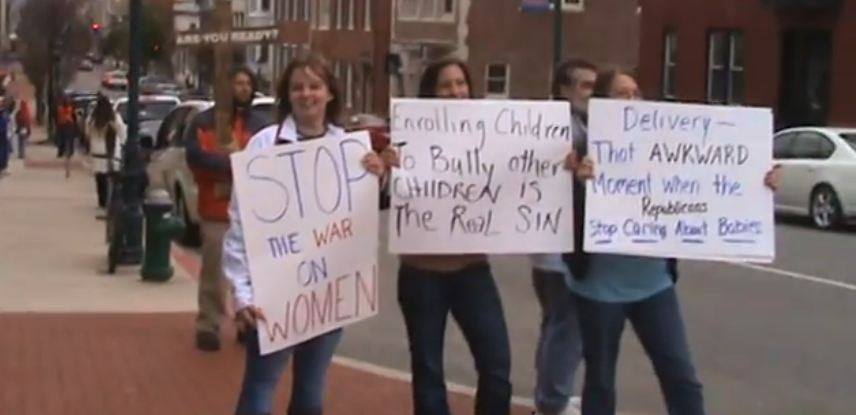 A group of three women counter protesting some religious pro-lifers with signs that say: Stop the war on women, Enrolling children to bully other children is the real sin, Delivery-That awkward moment when the republicans stop carring about babies