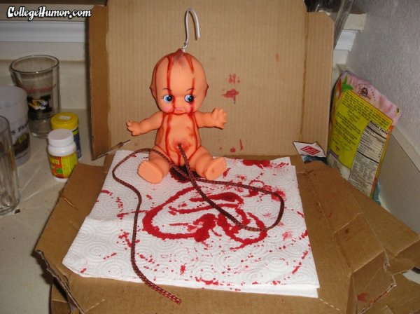A photo from College Humor.com of a Bloody baby doll with a hanger through its head sitting inside a pizza box