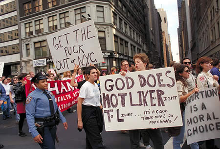 Photo of a march in NYC with signs that read: God does not like right to lifers...its a good thing she's so forgiving!