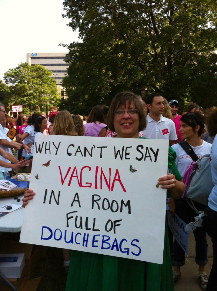 A photo of a female protester and her sign: Why cant we say Vagina in a room full of D***HBags