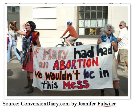 A picture of two abortion supporters in costumes holding a banner that says: If Mary had had an abortion we wouldnt be in this mess