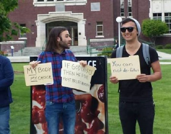 Created Equal set up a graphic abortion display at a college campus and some pro-choice men came, stood in front of the signs and had signs of their own that said: My Body My Choice, and You can not de-fetus