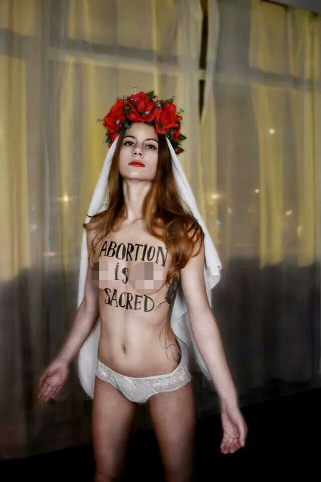 Photo of a topless female with Abortion is Sacred written on her chest