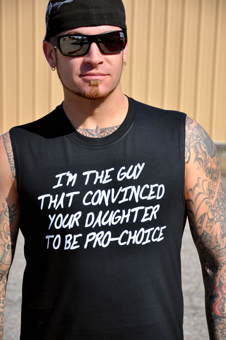 A male with tattoo's wearing a black t-shirt that says: I'm the guy that convinced your daughter to be pro-choice