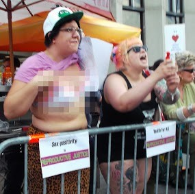 Photo from Reproductive Justice of two females one is lifting up her shirt flashing the on lookers