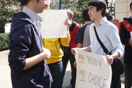 A photo of a male holding a sign that reads: My Body My Choice