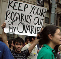 A male protester holding a sign that says: Keep your rosaries out of my ovaries