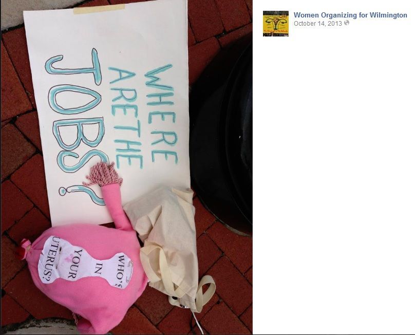 A photo that the group Women Organizing for Wilmington posted on their facebook page of a poster that says "Where are the Jobs?" with a homemade uterus that is saying "Who's in your uterus?"