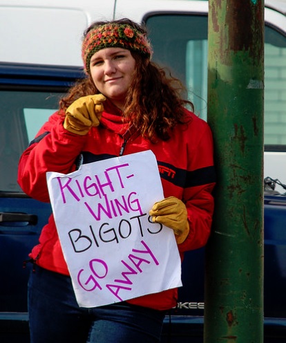 A female protester holding a sign that says: Right-Wing Bigots Go Away