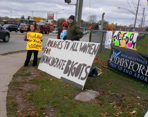 A 40 Days for Life protest where pro-choice couple counter protested with a sign that says: Apologies To All Women For Inconciderate Bigots