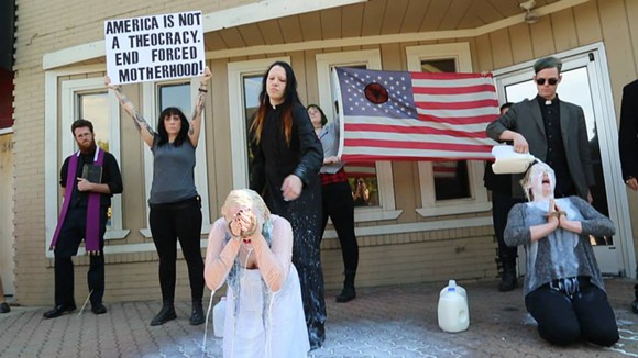 Satanic group protests pro-life activists by dressing up as priests and pouring milk on women... for whatever reason...