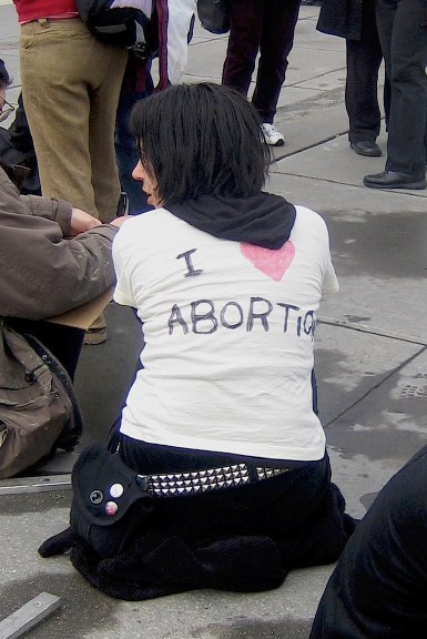 Pro-Choicer wears a t-shirt with the words "I heart Abortion" written on the back.