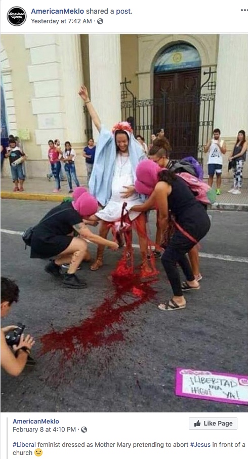 A woman dressed as Mary puts on a display in front of a church where baby Jesus is aborted.
