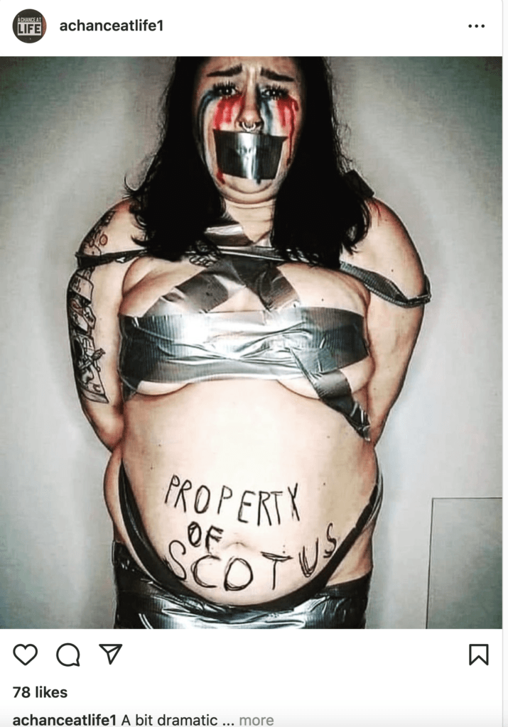 Woman bound with duct tape and "Property of Scotus" written on her abdomen. 